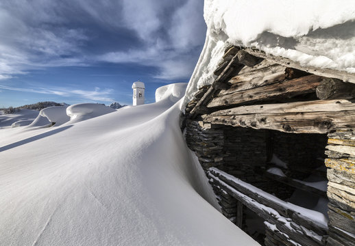 A mountain hut emerging from thick snow after a heavy snowfall in the Alpe Scima, Valchiavenna, Lombardy