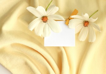yellow fabric wavy background blank slip memory paper for notes fresh flowers warm summer autumnal tones
