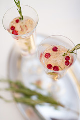 Two glasses of Champagne and rosemary branch on a table