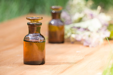 Fototapeta na wymiar essential oil in little bottle and medical flowers herbs