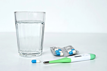 Pills, thermometer and glass of water