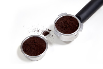 Portafilter filled with ground coffee on a white background