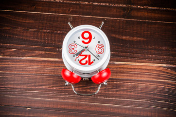 Alarm clock on wooden board background