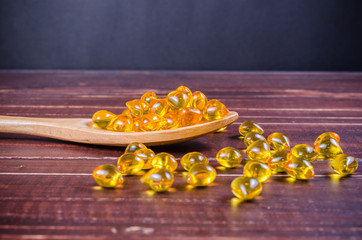 Fish oil on wooden spoon with wooden texture background