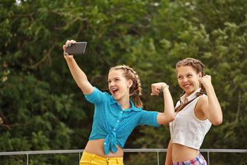 Obraz premium Best girlfriends are photographed in park. Photo phone selfie.