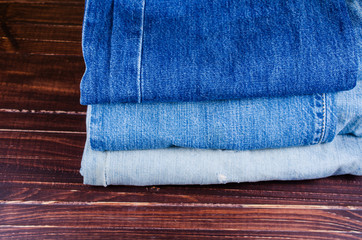 Obraz na płótnie Canvas blue jeans on wooden board background