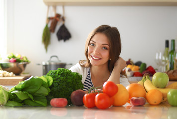 Young woman standing near desk in the kitchen