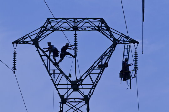 Workers on pylon, Brittany, France 