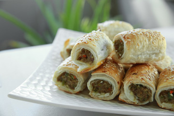 Homemade sausage rolls on white plate