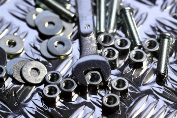 Nuts bolts washers spanner.
Various nuts bolts washers and a spanner on a steel background.