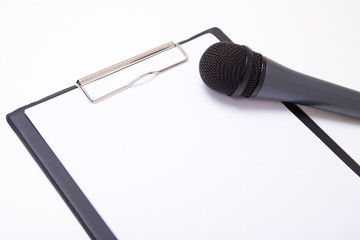 speech or interview concept - microphone and clipboard with blan