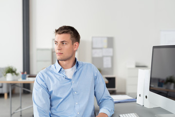 büroangestellter sitzt am schreibtisch