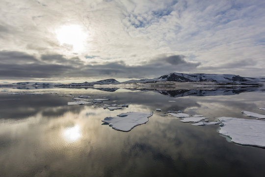 Sun and sky reflected in the calm waters of Olga Strait, Svalbard, Arctic