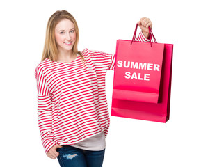 Woman holding with shopping bag and showing summer sale