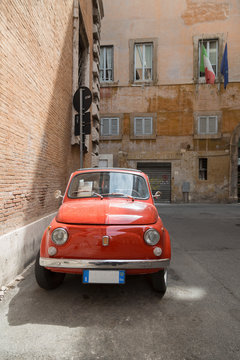 Small old Fiat 500 car parked on a back street in Rome, Lazio