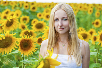 Portrait of a beautiful young blonde woman in a white dress on a