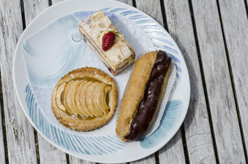 Éclair au chocolat, Apfeltartelett, Erdbeerschnitte auf einem Teller