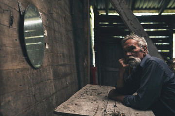 Pensive Bearded Man Sitting Inside a Wooden House