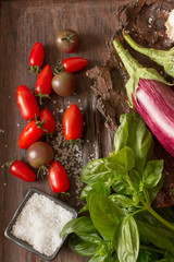 ripe eggplant with tomatoes and salt on a wooden background