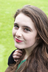 Headshot of a beautiful young woman, with unique hazel eyes, olive skin and wavy brown hair.