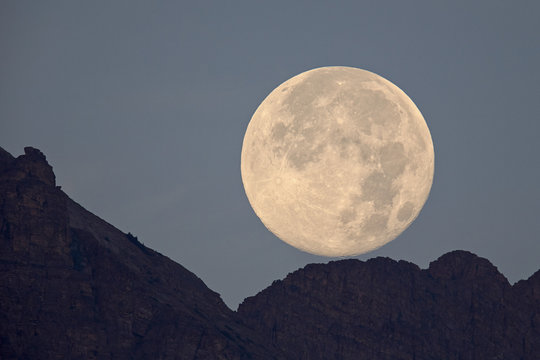 Full moon setting above a ridge, Glacier National Park, Montana