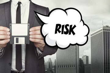 Risk text on speech bubble with businessman holding diskette