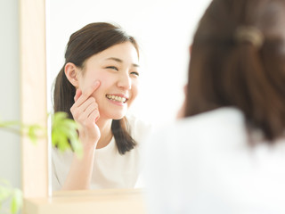 スキンケア・鏡を見る若い女性
