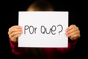 Fototapeta premium Child holding sign with Portuguese word Por Que - Why