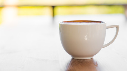 Coffee in white cup on wood table