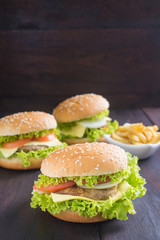 Delicious homemade hamburger with french fries on wooden desk.