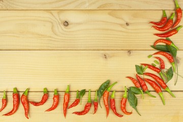 Freshly picked chili peppers on a wooden table. Preparation for the domestic processing of a crop. Decoration of chilli peppers. Place for text menu. Healthy fresh food.
