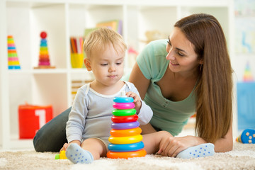 Obraz na płótnie Canvas child and woman play together in nursery