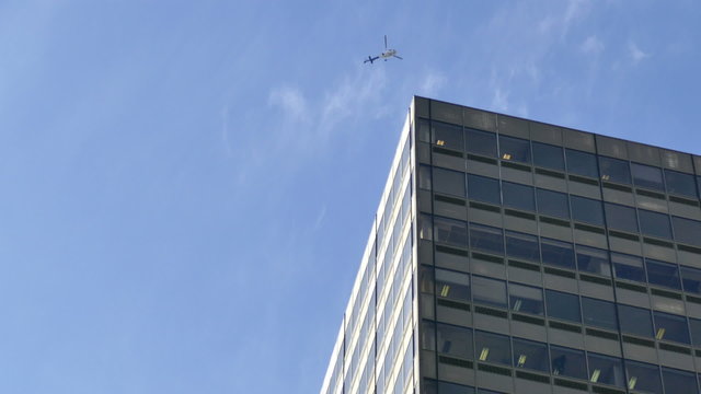Surveillance helicopter flying around building corner