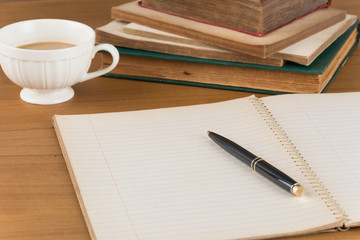old notebook with pen on wood table