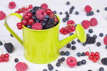 mixed berries in small decorative watering can