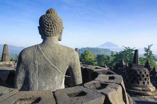 Buddha sitting in a stupha in the temple complex of Borobodur, Java, Indonesia