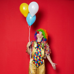 clown with balloons on red background