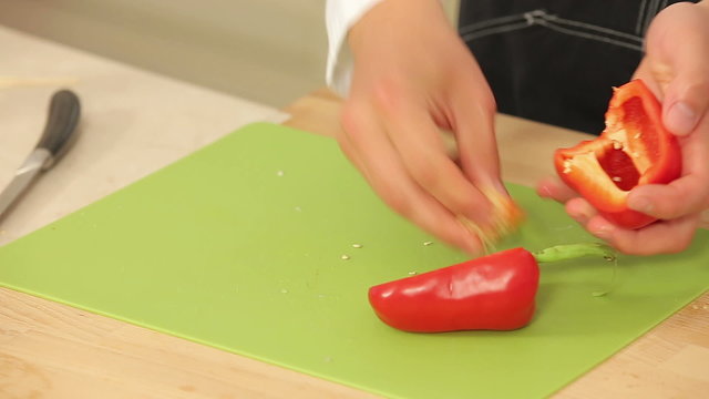 Cheff is Cutting Red Paprika on a Cutting Board