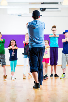 Dance teacher giving kids Zumba fitness class