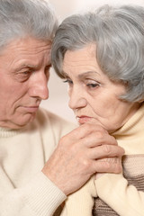 Close-up portrait of sad elder couple on a black background. Iso