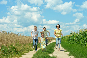 Fototapeta premium Happy family jumping on field 