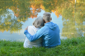 Senior couple sitting near lake
