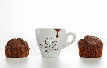 Coffee cup with two chocolate muffins. White background