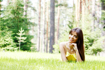 young woman in yellow dress lying on grass