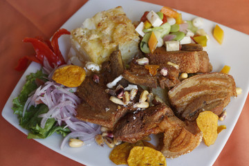 Peruvian food, Chicharron (fried pork) with potatoes, onion garnish, canchita.