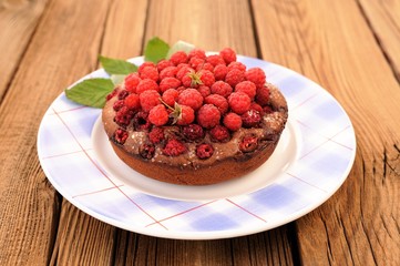 Homemade delicious chocolate cake with fresh wild raspberries an