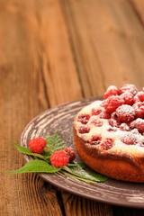 Homemade yummy cake with fresh wild raspberries and leaves decor