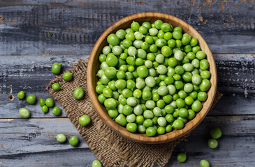 Green peas in wooden bowl