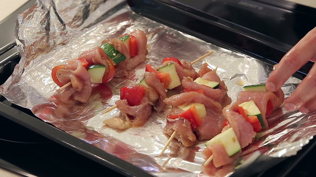 Chef is Pouring Marinadeand Sesame on Raw Kebabs with Meat and Vegetables