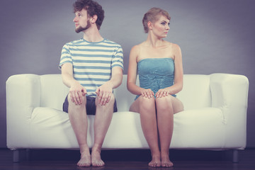 Man and woman in disagreement sitting on sofa